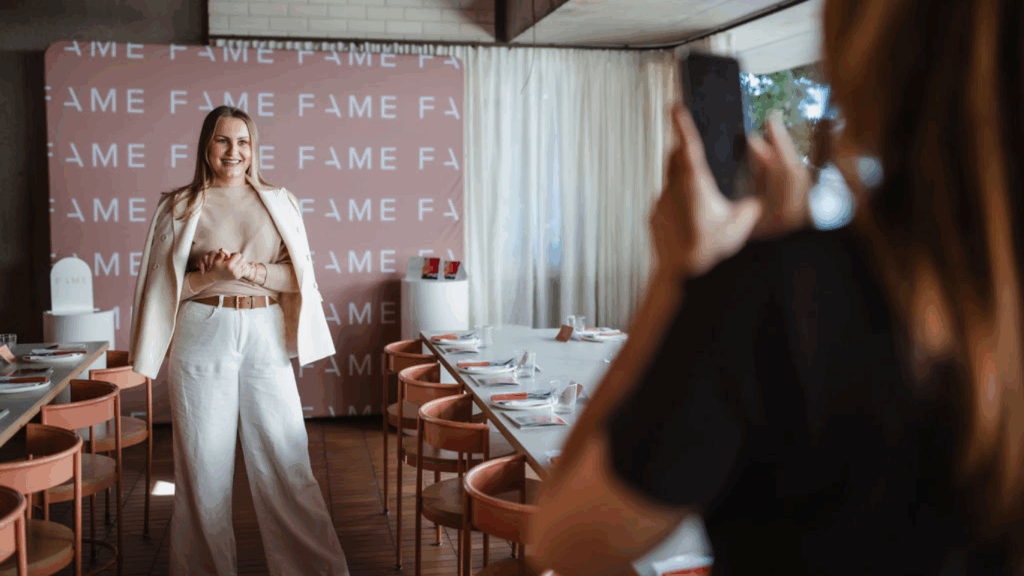 Behind-the-scenes shot of FAME team recording social media content in a styled event space during their brand activation setup.