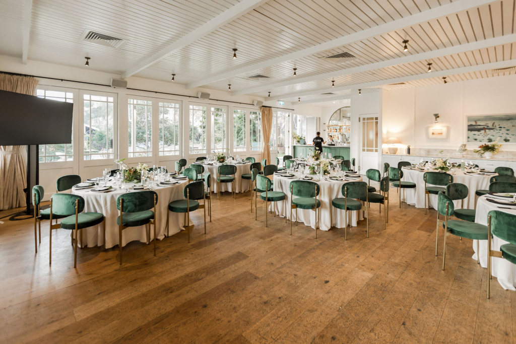 wide angle shot of the full event setup showing 3 round table with green theme